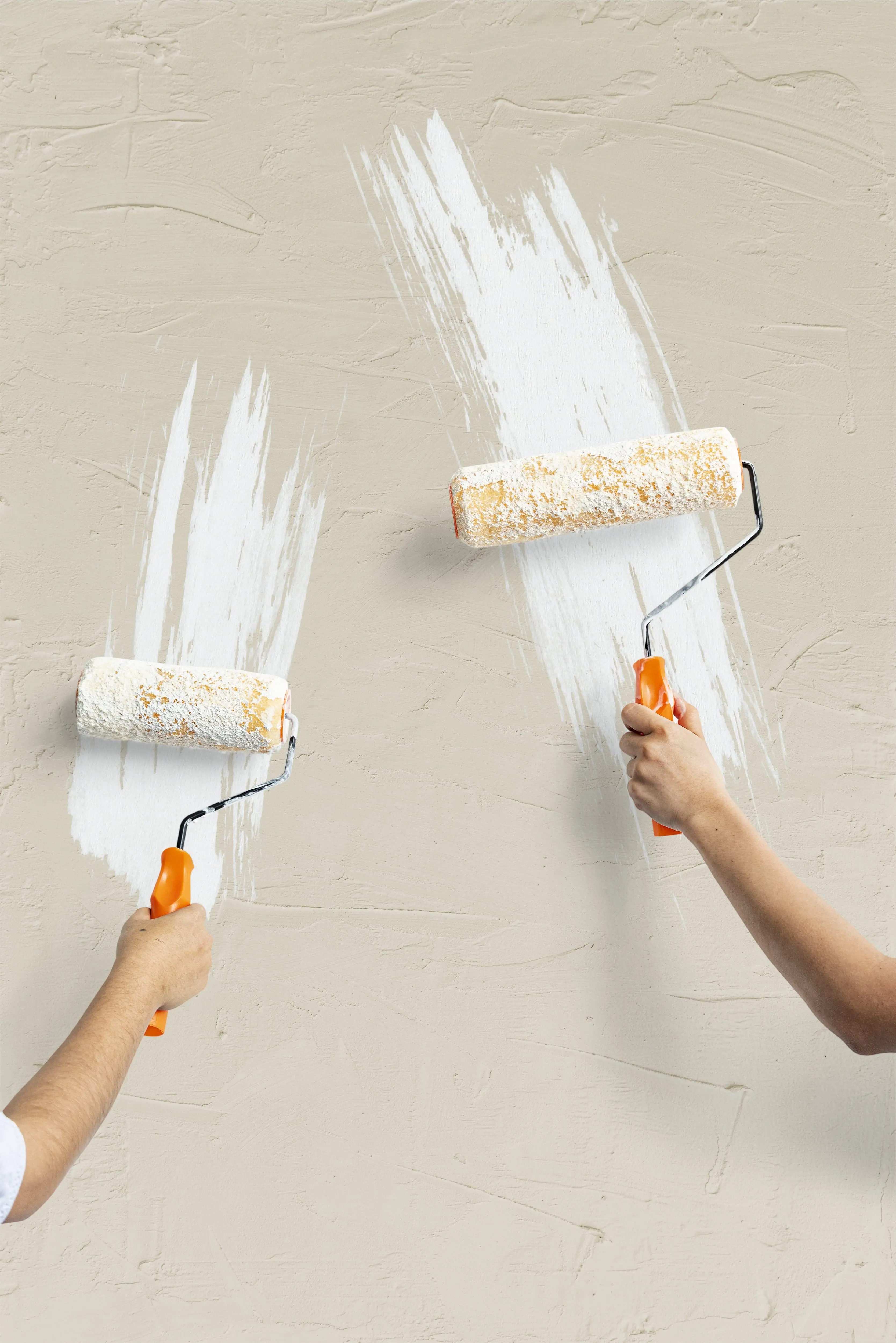 two-hands-painting-wall a person painting a wall with white paint